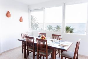 une salle à manger avec une table et des chaises et l'océan dans l'établissement Malagueta 17 FreshApartments by Bossh! Apartments, à Malaga