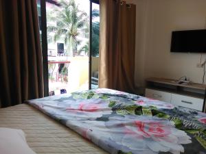 a bedroom with a bed with flowers on it at NB House in Karon Beach