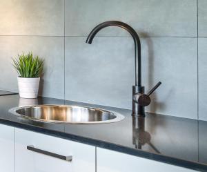 a kitchen sink with a faucet on a counter at Crest on Park in Melbourne