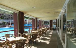 a row of tables and chairs on a balcony with a pool at Centro Vacanze Cugnana Verde in Marina di Portisco