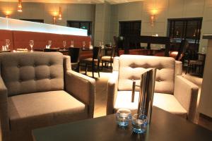 um restaurante com duas cadeiras e uma mesa com copos em The Lerwick Hotel em Lerwick