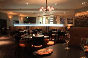 a restaurant with tables and chairs and a chandelier at The Lerwick Hotel in Lerwick