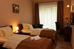 A bed or beds in a room at Maya Panzio-Rezidencia
