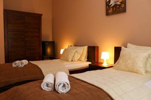A bed or beds in a room at Maya Panzio-Rezidencia