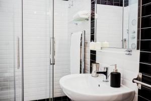 ローマにあるBMGA l Stylish Industrial Termini Apartmentの白いバスルーム(シンク、シャワー付)