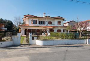 a large house with a fence in front of it at Villa Gloria in Marina di Pietrasanta