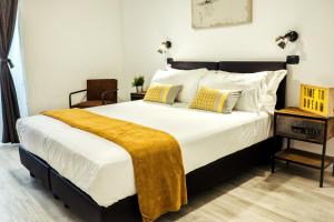 ローマにあるBMGA l Stylish Industrial Termini Apartmentのベッドルーム1室(大型ベッド1台、黄色い毛布付)