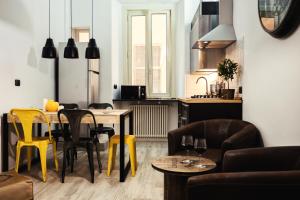 ローマにあるBMGA l Stylish Industrial Termini Apartmentのリビングルーム(テーブル、椅子付)
