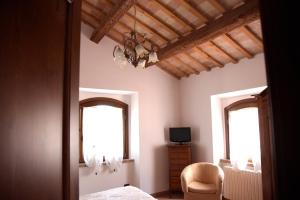 a bedroom with two windows and a bed and a chair at L'Oasi di Pierino in Grottazzolina
