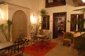 uma sala de estar com cadeiras e uma mesa num quarto em Riad Aubrac em Marrakech