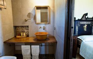 a bathroom with a sink and a mirror and a bed at Baglio Giammaccaro in Castelluzzo +43 photos