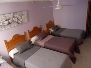 a bedroom with two beds and two lamps at Hostal Gonzalez in Marbella