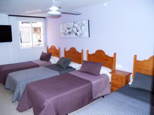 a hotel room with two beds and two lamps at Hostal Gonzalez in Marbella