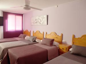 a bed room with two beds and two nightstands at Hostal Gonzalez in Marbella
