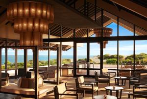 a lobby with chairs and tables and windows at Jetwing Yala in Yala