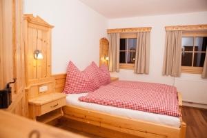 um quarto com uma cama com almofadas vermelhas e brancas em Bifeis Hütte em Altenmarkt im Pongau
