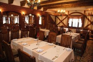 a dining room with tables and chairs with white table cloth at Hotel Pod Kluką in Słupsk