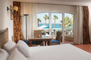 a hotel room with a bed and a view of the ocean at Porto Sokhna Beach Resort in Ain Sokhna