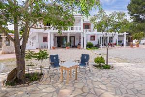 una mesa y sillas frente a una casa en Villa Felisa, en Sant Josep de sa Talaia