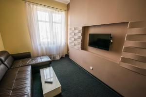 sala de estar con sofá y TV en la pared en Kuźnia Smaku, en Ełk