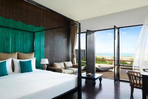 a bedroom with a bed and a couch and a balcony at Jetwing Yala in Yala