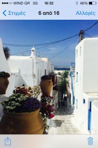 a view of a narrow street with flowers inront of buildings at Pensione Della Nonna in Mikonos