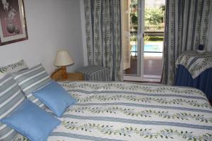 a bedroom with a bed with blue sheets and a window at Apartamento en Familia in Comarruga +27 photos