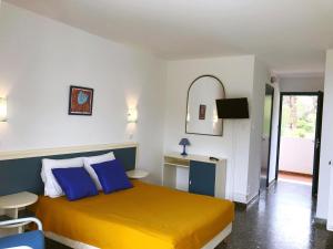 アジャクシオにあるHotel la Parataのベッドルーム(黄色のベッド、青い枕付)