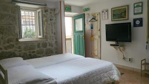 1 dormitorio con 1 cama, TV y ventana en Apartment Dubrovnik Center en Dubrovnik