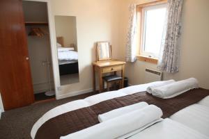 um quarto de hotel com uma cama e uma janela em Castleyards Apartment 2 em Kirkwall