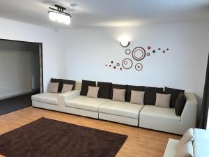 a living room with a white couch with pillows on it at Casa Mais Brașov Guesthouse with Free Parking in Braşov +31 photos