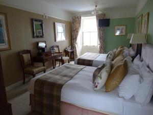 a hotel room with two beds and a desk at Port Charlotte Hotel in Port Charlotte
