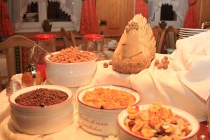 un tavolo con ciotole di cibo su un tavolo di Garnì Val de Costa a Canazei