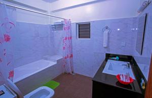La salle de bains est pourvue d'une baignoire, d'un lavabo et d'une douche. dans l'établissement Hotel Spring, à Pokhara