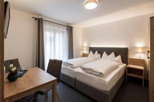 um quarto de hotel com uma cama e uma mesa em Garni Grünau em San Martino
