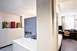 a white bathroom with a sink and a bedroom at Boutique Hotel Villa du Taur in Toulouse