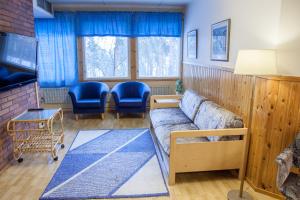 Una sala de estar con un sofá y sillas azules. en Camping Lappeenranta, en Lappeenranta
