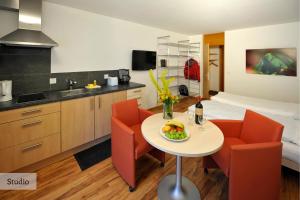 a kitchen with a table, chairs, and a coffee table at Serviced Apartments by Solaria in Davos