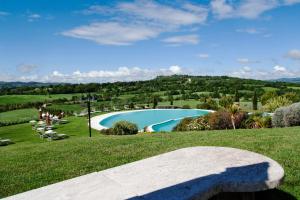 サトゥルニアにあるBagno Santo Residenceの草原のスイミングプールを望む