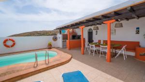 een villa met een zwembad en een tafel bij Villa with amazing views, jacuzzi and private pool in San Bartolomé