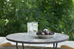 a table with a bowl of fruit and glasses of water at Palio Eleotrivio Guesthouse in Agios Lavrentios