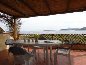 - une table et des chaises sur une terrasse avec vue sur l'océan dans l'établissement Appartamento I Ginepri, à Marina di Portisco