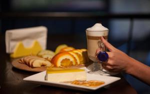 a table with a plate of cheese and a drink at Art Hotel Claude Monet in Tbilisi City