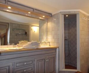 a bathroom with a sink and a shower with a mirror at Le Bastidon Saint-Michel in Sainte-Maxime