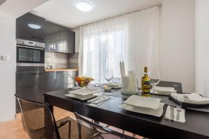 a kitchen with a black table with chairs and wine glasses at Monte & Paradiso in Pula