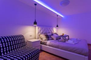 a purple bedroom with a bed and a couch at Monte & Paradiso in Pula
