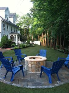 um grupo de cadeiras azuis em torno de uma mesa circular num quintal em Abalonia Inn em Ogunquit