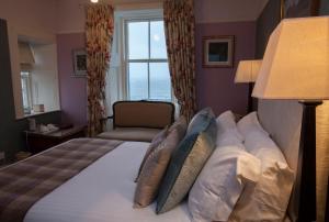 a bedroom with a bed with pillows and a window at Port Charlotte Hotel in Port Charlotte