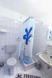 a bathroom with a toilet and a shower curtain at Villa Lesic in Dramalj