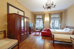 a bedroom with two beds and a chandelier at Calliope Apartments in Krakow